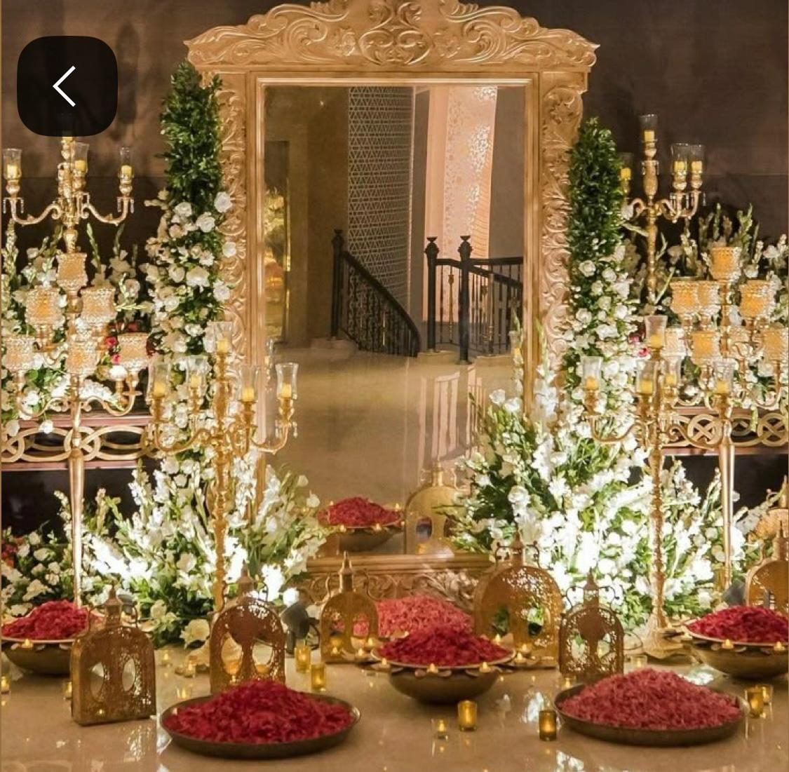 Gold mirror backdrop with candelabras and rose petal bowls