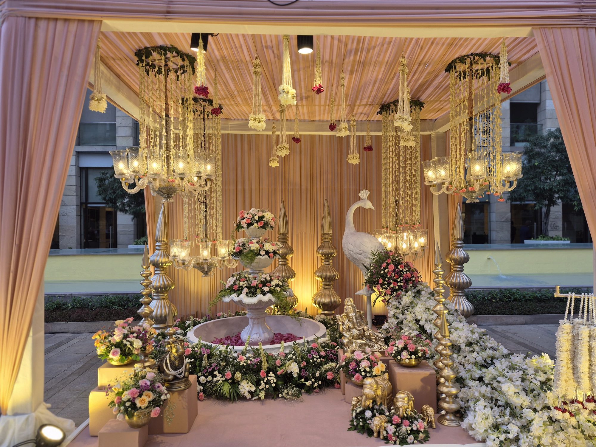 Pink and peach mandap with peacock statue
